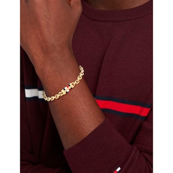 Moderne guldtonet armbånd fra Tommy Hilfiger med logo og signaturstriber