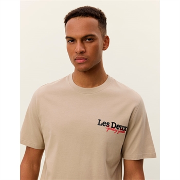 Stilren beige t-shirt med ikonisk logo på brystet fra Les Deux