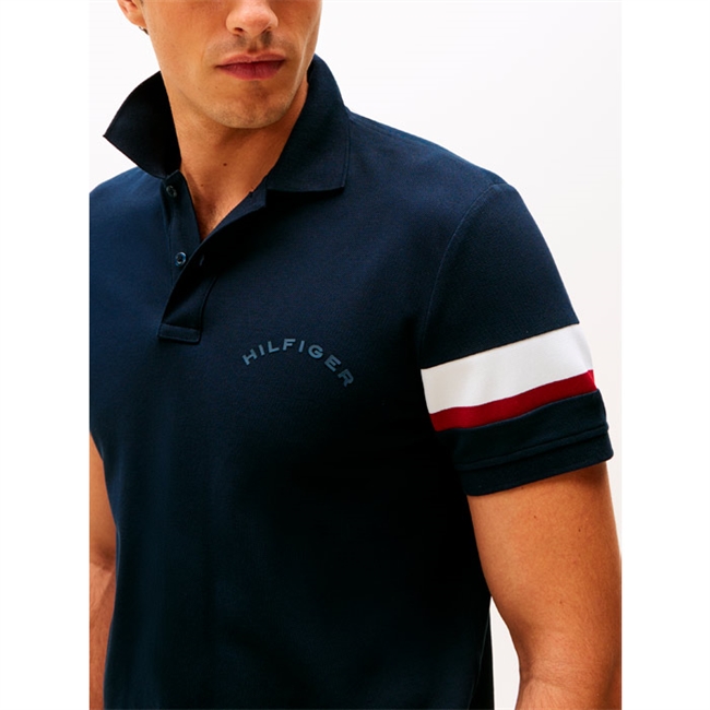 Moderne navy sports polo fra Tommy Hilfiger med brandets ikoniske striber ved venstre ærme